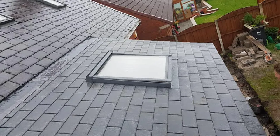 A little boy standing on top of a roof.